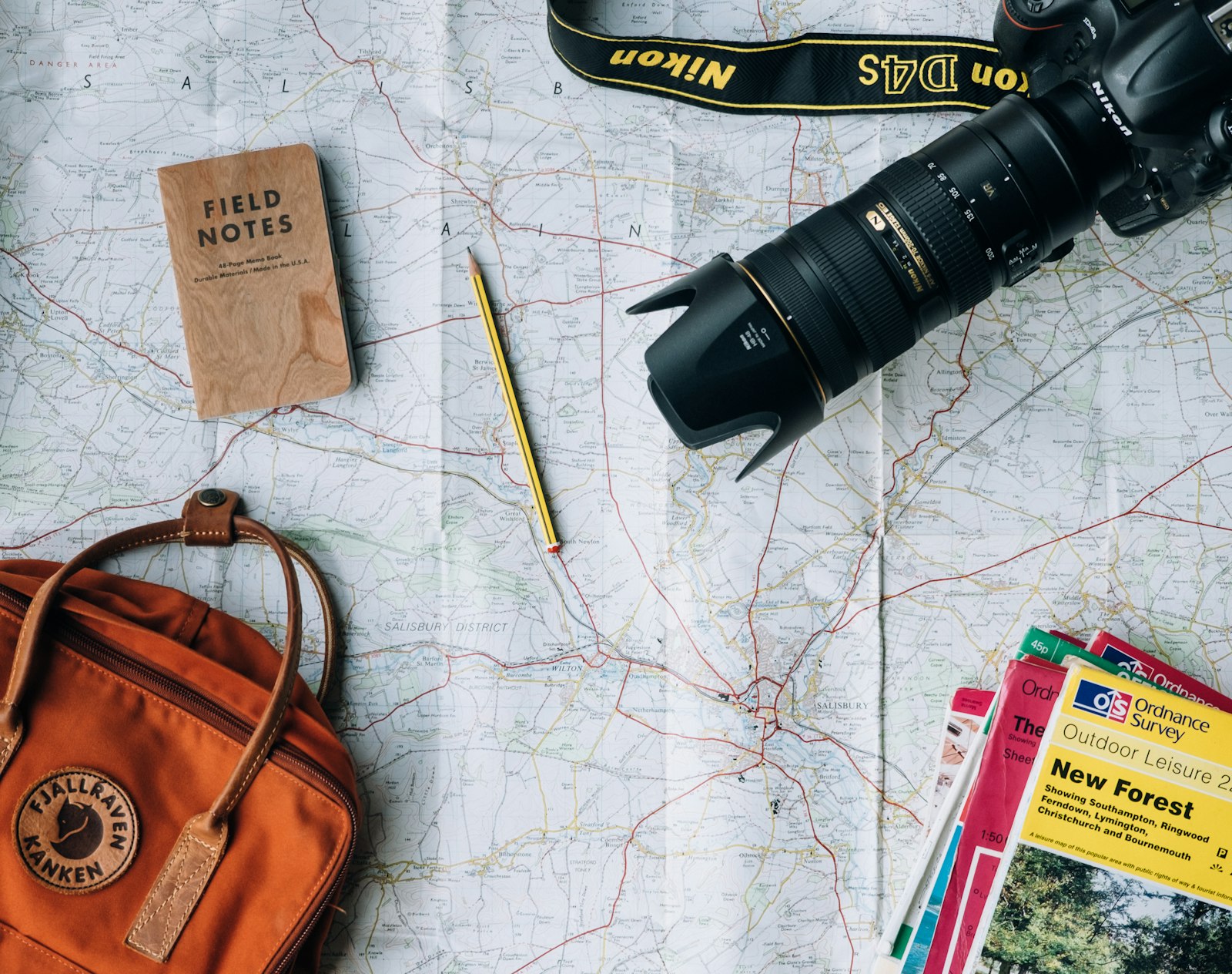 A neatly packed open suitcase on a bed with folded clothes, a small notebook, and soft evening lamplight, evoking calm preparation rather than rushed packing